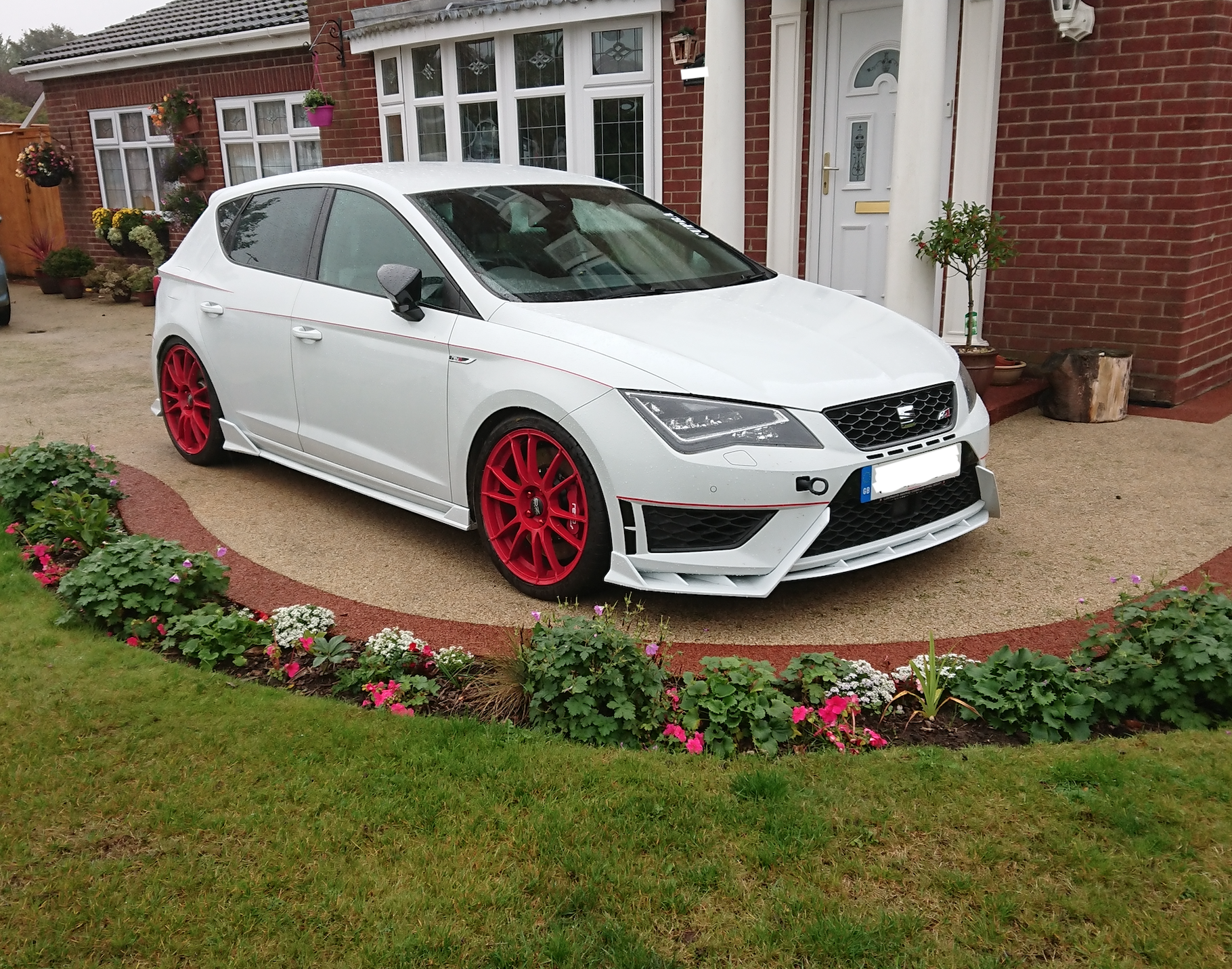 A car parked in front of a house
Description automatically generated