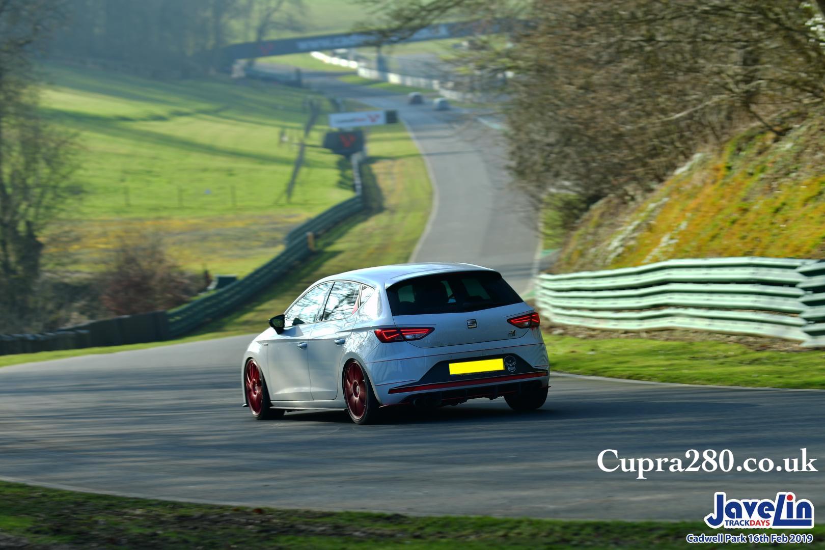 A person riding on the back of a car going down the road
Description automatically generated