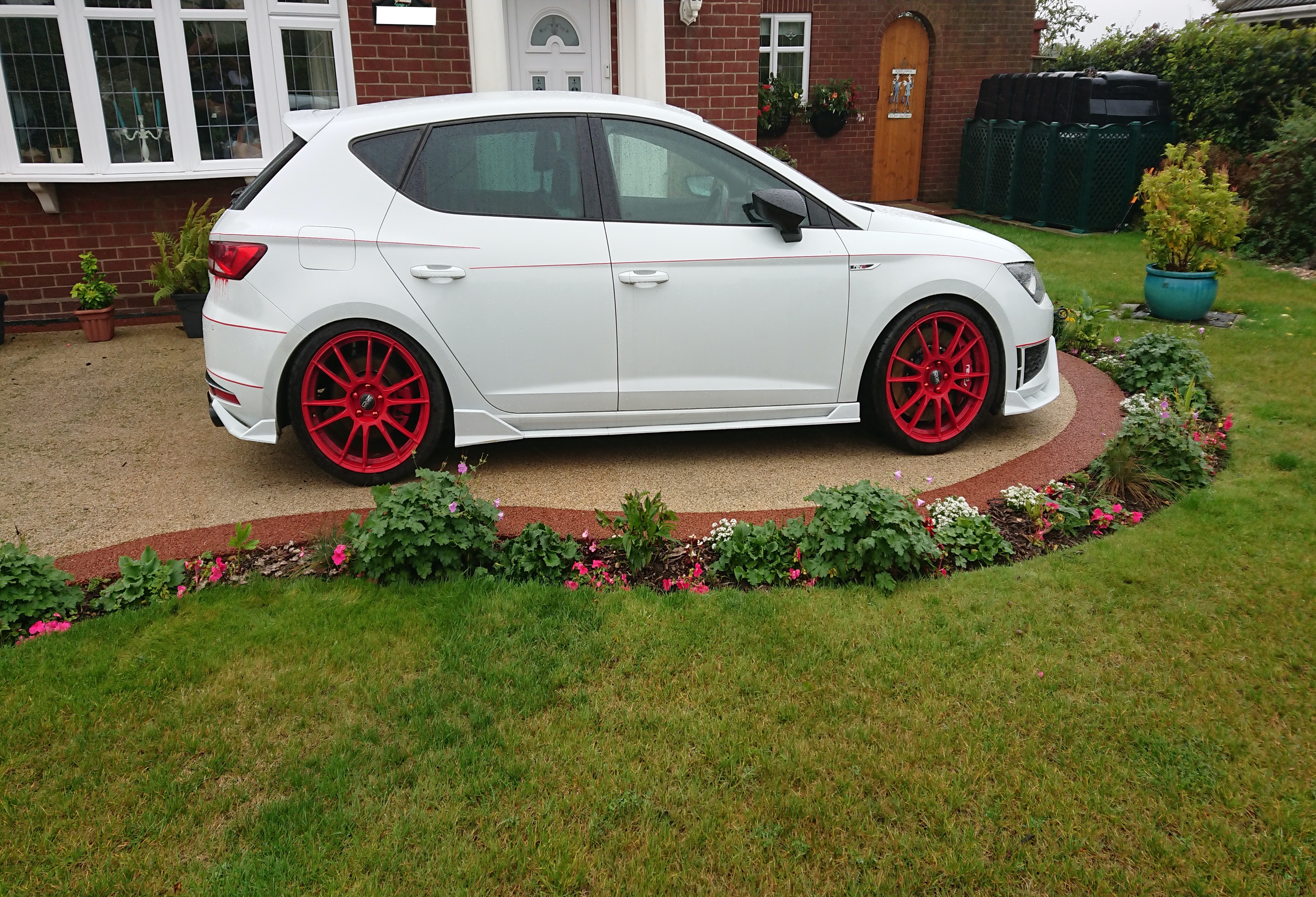 A car parked in front of a house
Description automatically generated
