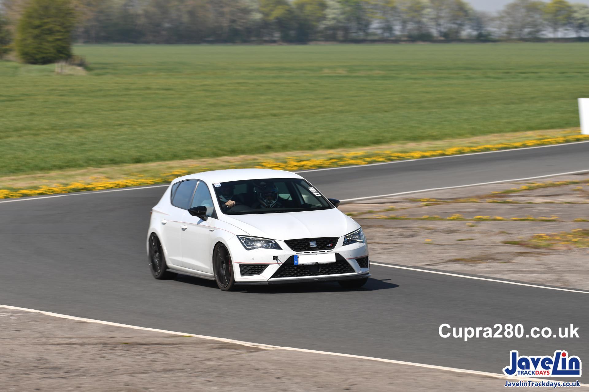 A person driving a race car on a road
Description automatically generated